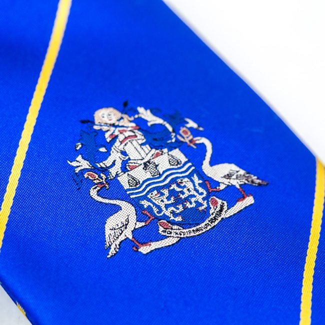 Close up of blue tie with embroidered logo