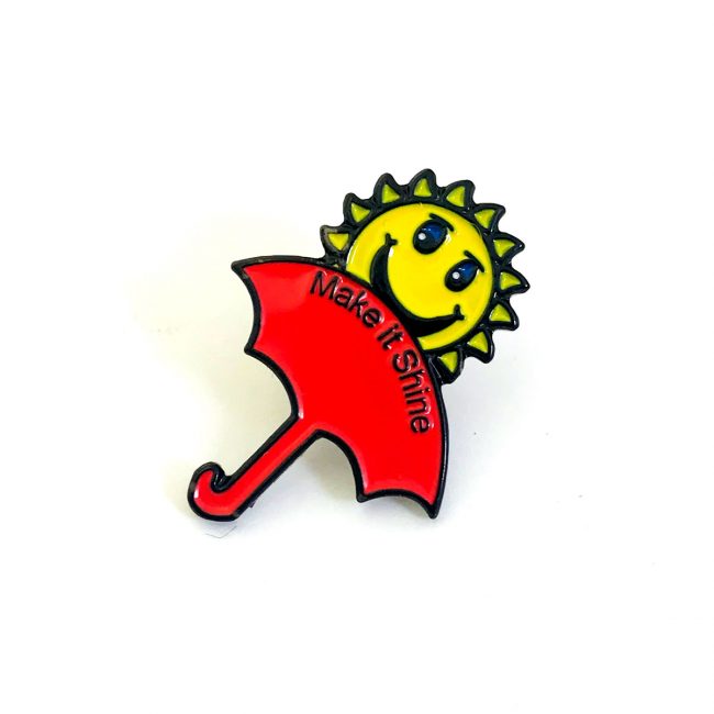 Red umbrella and yellow sun pin badge