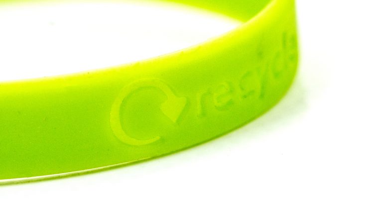 Close up of green wristband that says 'recycle'