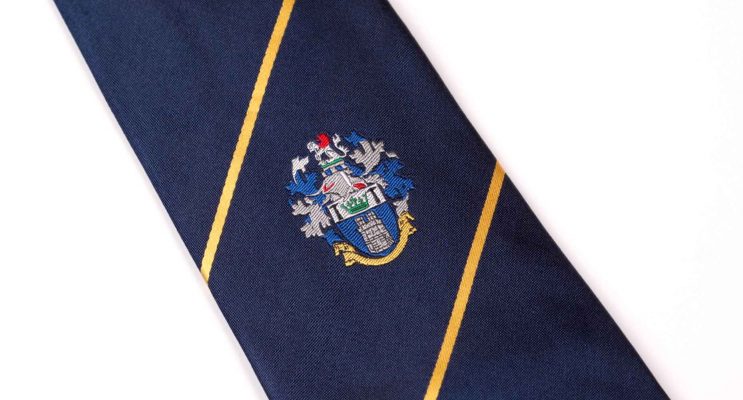 Dark navy blue tie with two gold stripes and embroidered logo