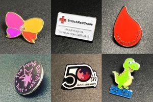 Group of six metal charity badges