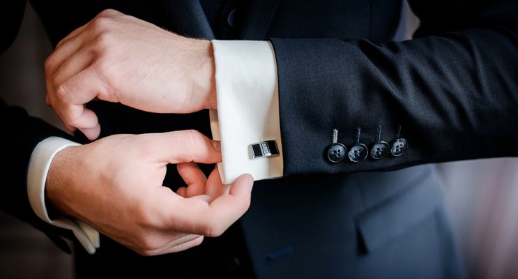 Man putting on cufflinks for black tie event