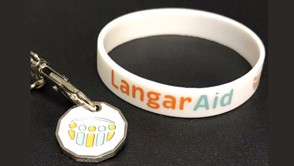 Langar Aid charity wristband and trolley coin with logo