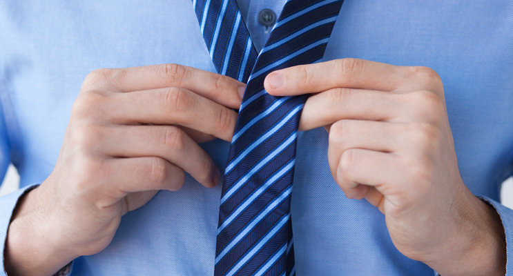 Man tying blue stripe tie